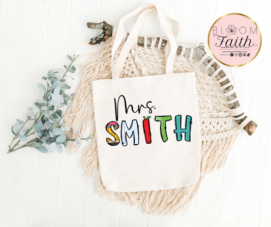 Personalized tote bag with teacher's name with school-themed letters.