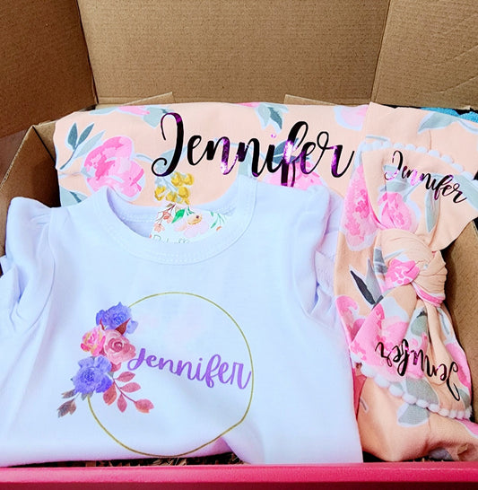 Baby girl personalized swaddle blanket, headband or beanie, and onesie gift set.